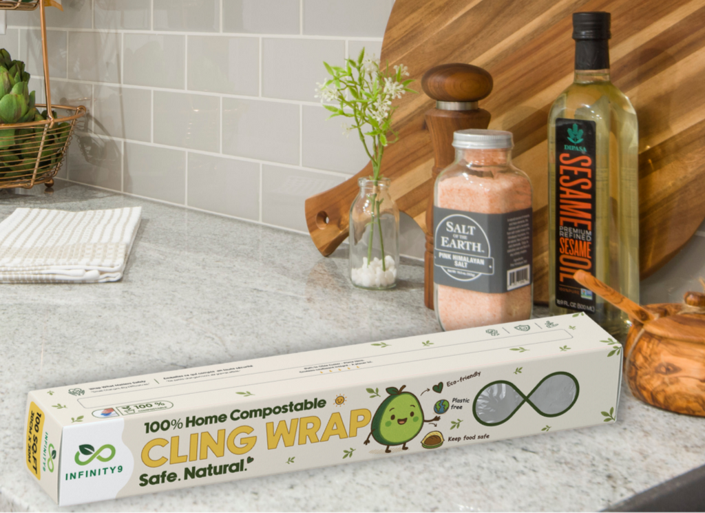 Box of Infinity9 cling wrap on a kitchen counter with a cutting board and kitchen items in the background.