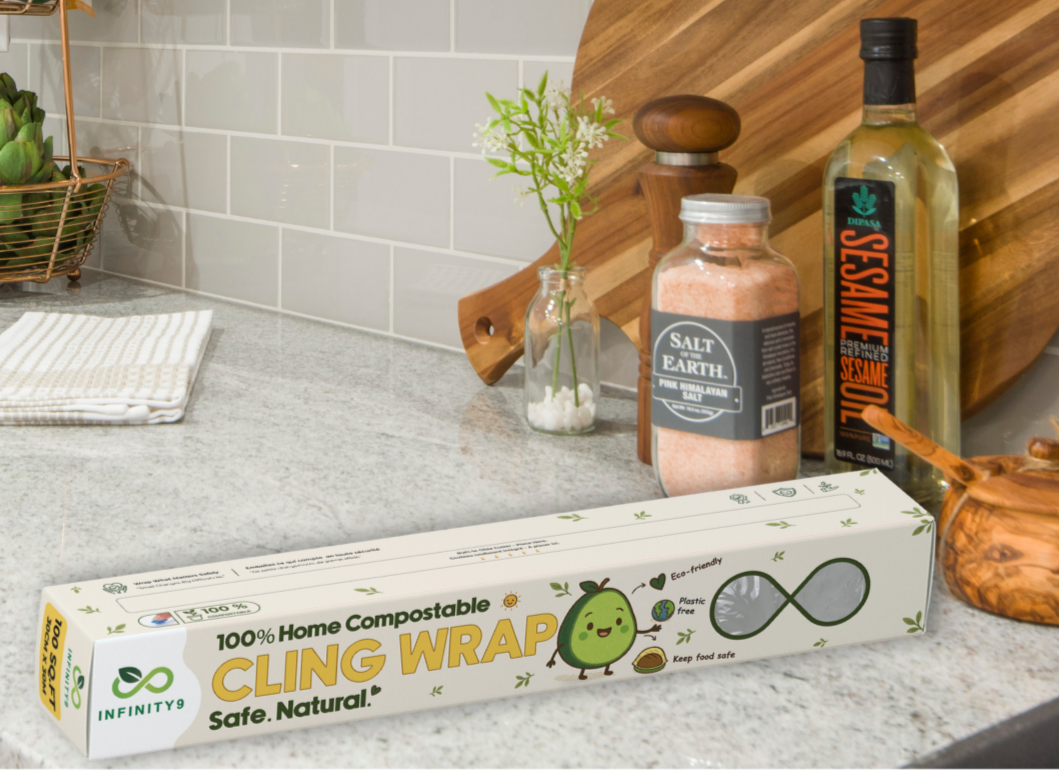 Box of Infinity9 cling wrap on a kitchen counter with a cutting board and kitchen items in the background.